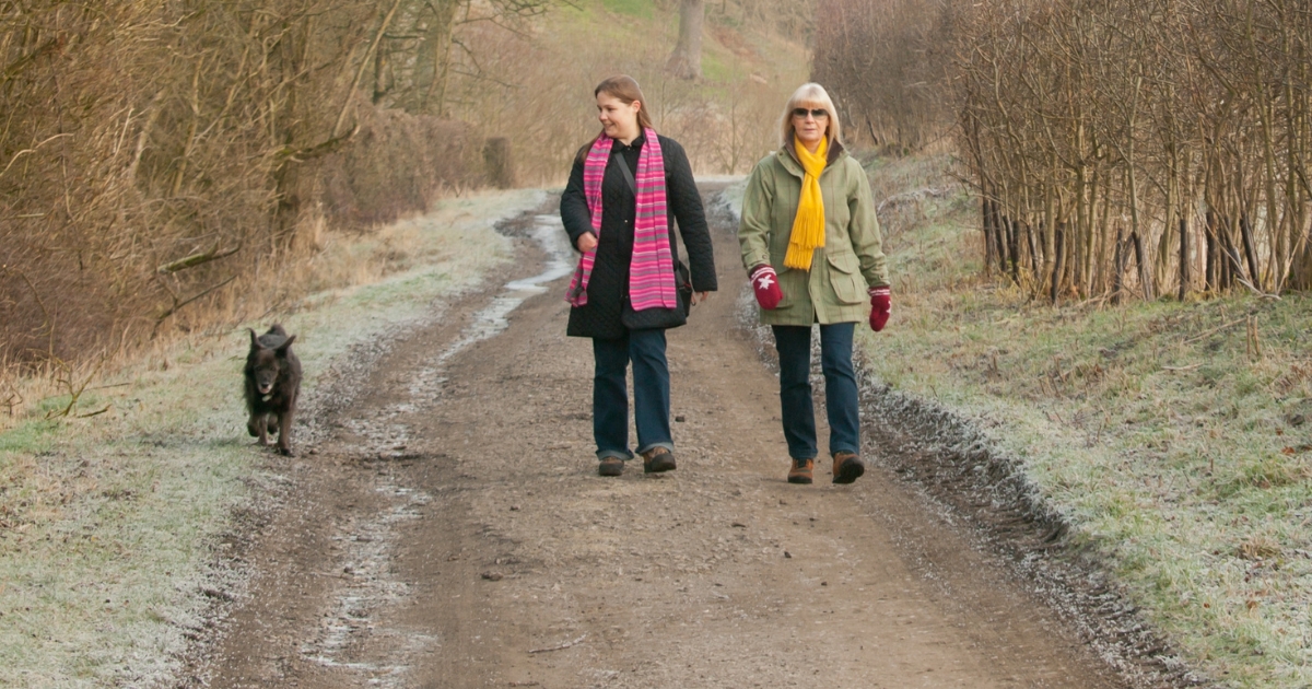 new_year_new_you_website_properties_img_extension_1200x630 - 1 Two women and a dog walking a trail in winter