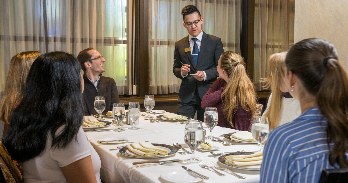 CANR AGcelerate students sit at a table with professor for formal etiquette dinner
