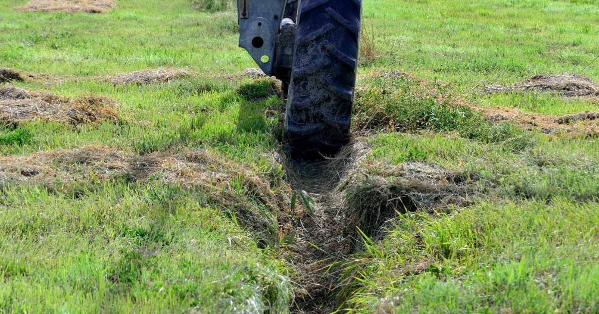 The wheel of an irrigation unit stuck in a muddy rut.