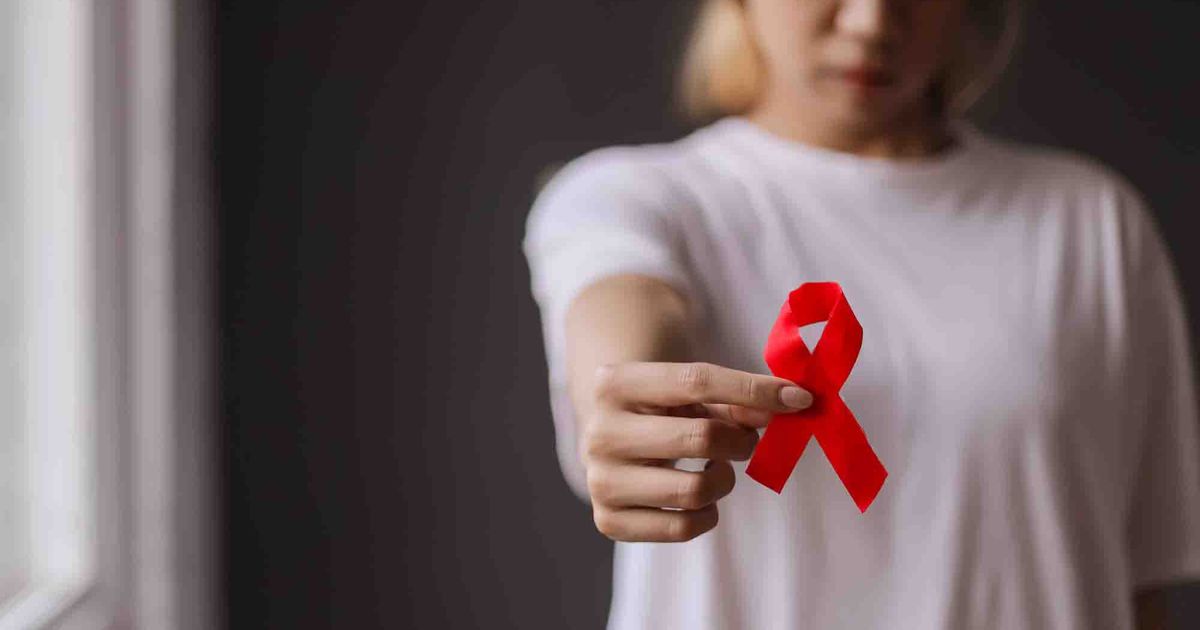 sad_october_website_properties_img_extension_1200x630 - 1 A woman holding a red ribbon
