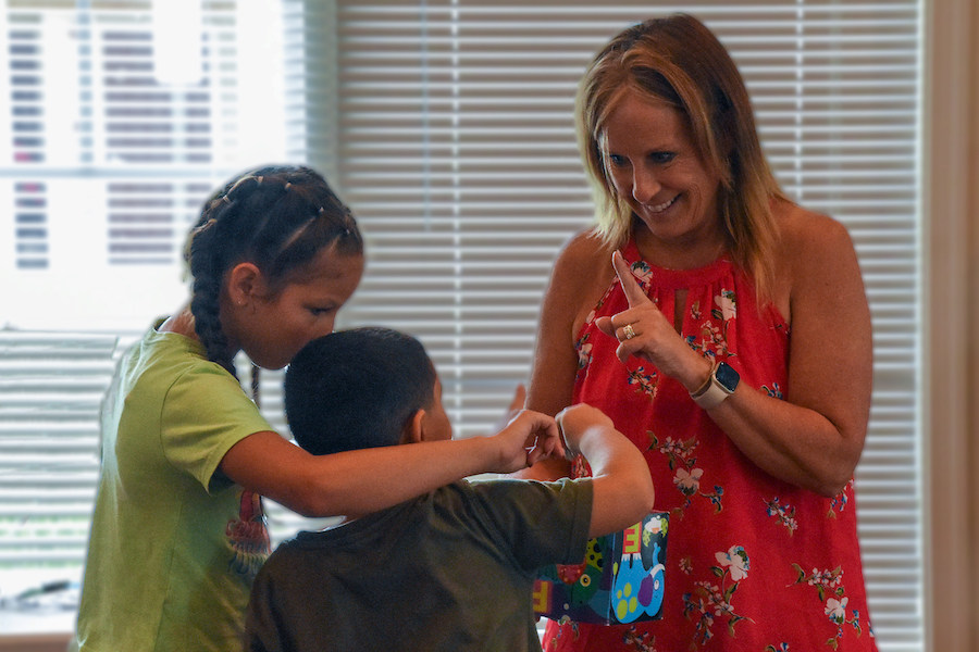 Kelly Sipple helps two young campers play a money-counting game in Seaford, Delaware.