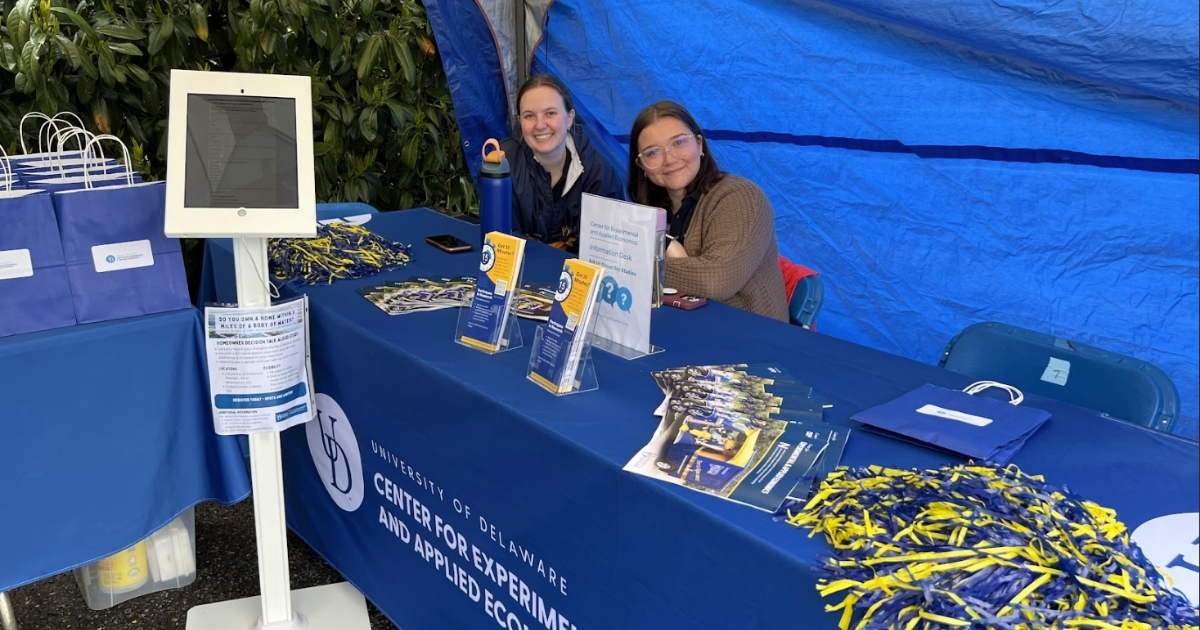 Laura Taylor and Elizabeth Anthony sit at an exhibit booth.