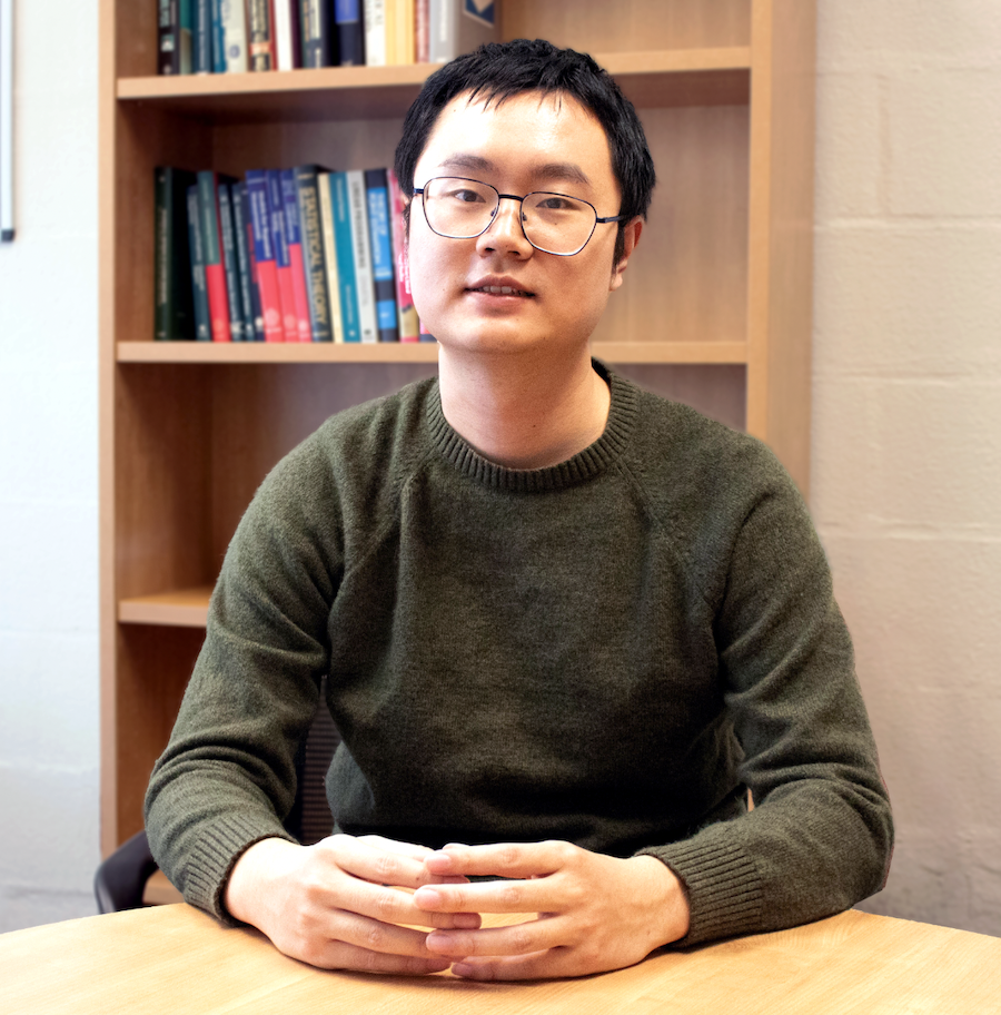Zhao posing at a table in Townsend Hall.