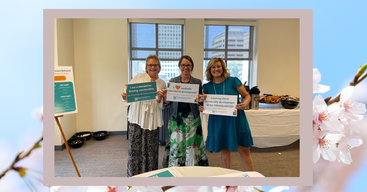 Nancy Mears with two others posing holding signs of encouragement