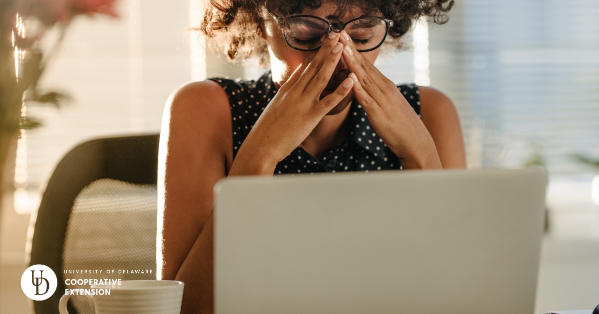 A woman in stress while sitting at her laptop