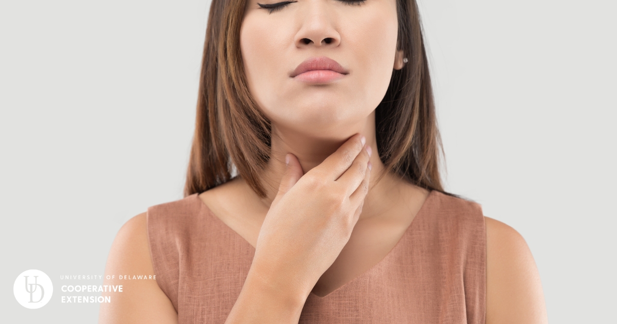 A photo of a female college student holding her sore throat