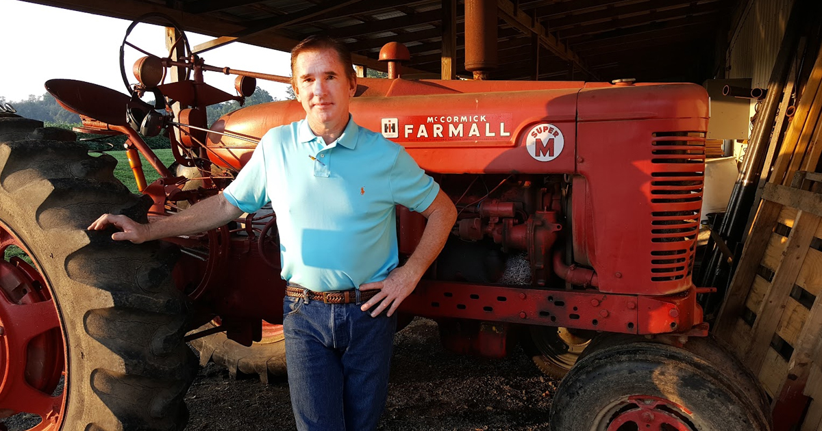 A young James posing in front of a tractor.