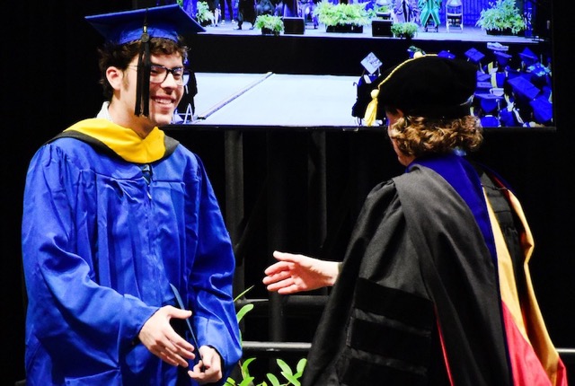 Carl shakes hands with Tanya Gressley on stage.