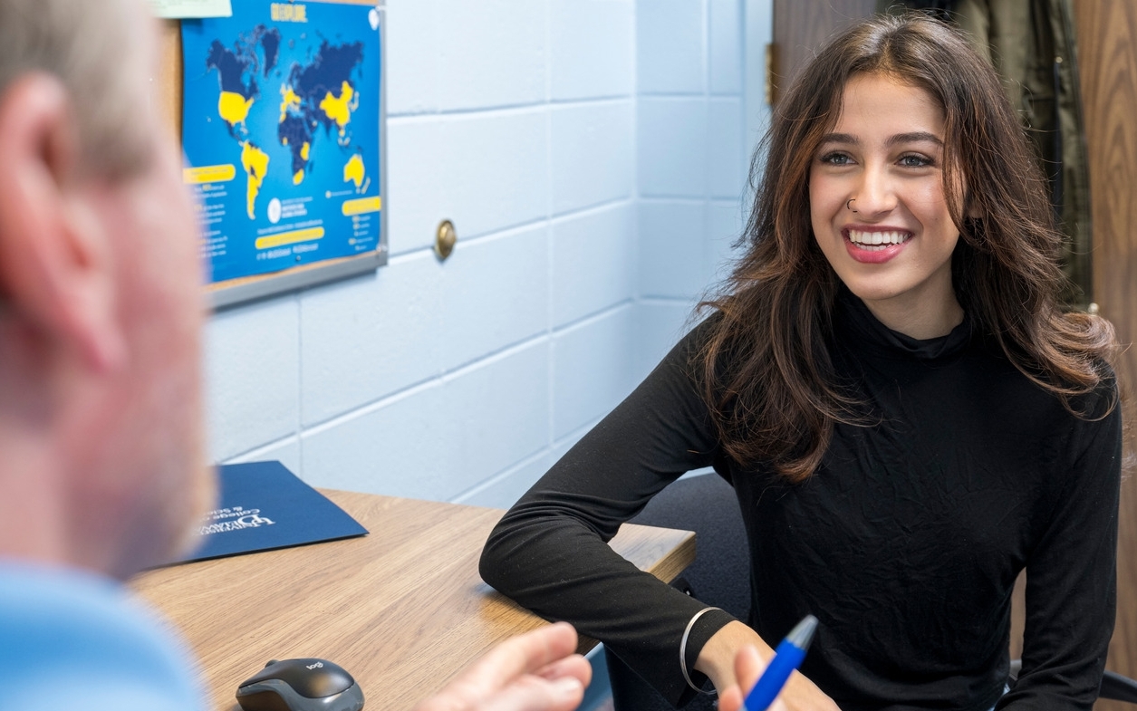 A University of Delaware undergraduate student sits inside an office and talks to her advisor in the Student Success Center.