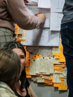 People in a classroom with sticky notes on wall