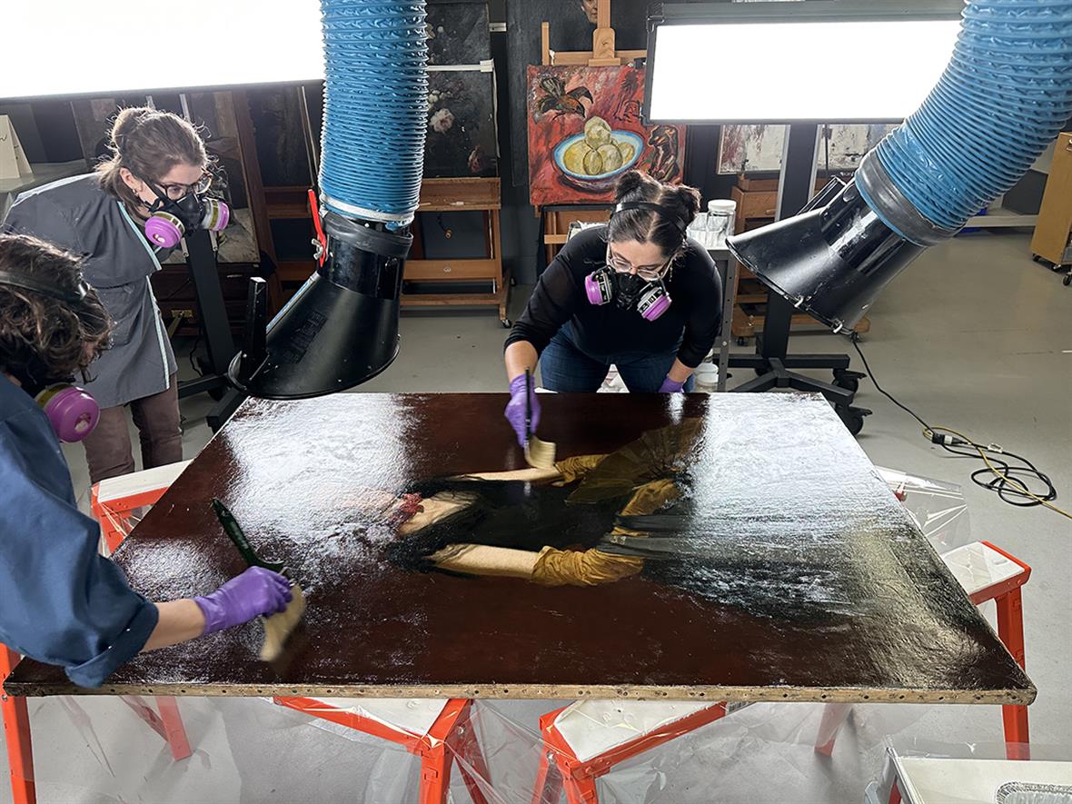 WUDPAC Class of 2024 Adriana Benavides and Lauren Bradley brush varnishing Letitia Wilson Jordan assisted by Ellen Nigro Adriana Benavides and Lauren Bradley brush varnishing a painting