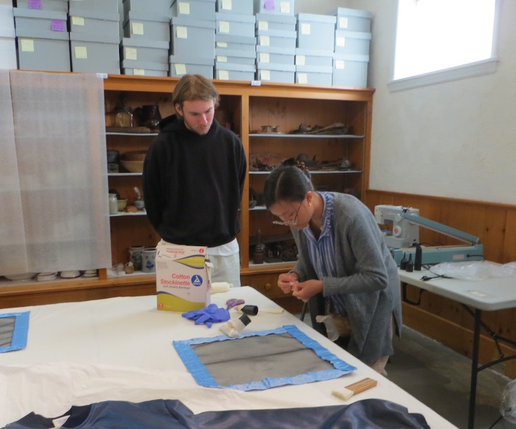 Binh-An showing the interns how to vacuum garments. Binh-An showing the interns how to vacuum garments.
