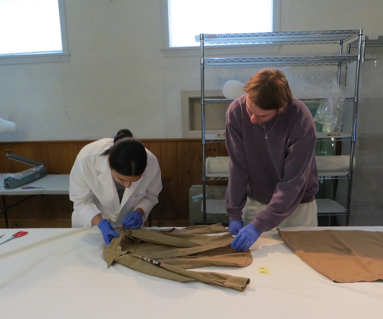 Anamaria and Jack examining a garment for condition issues and evidence of pest damage prior to freezing. Anamaria and Jack examining a garment