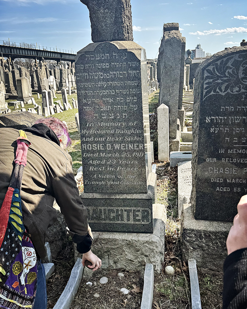 Person placing an object next to tombstone
