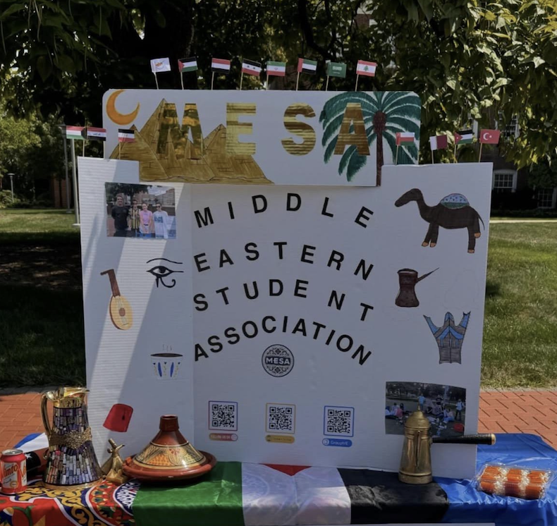 A trifold poster that says Middle Eastern Student Association and showcases some cultural items on a table.