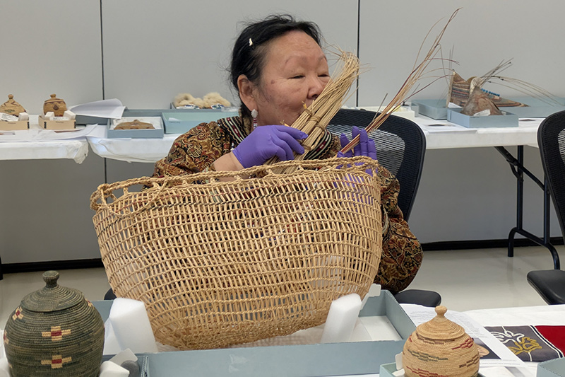 Cup’ik Elder Emily Johnston breathing in the scent of home from a basket woven