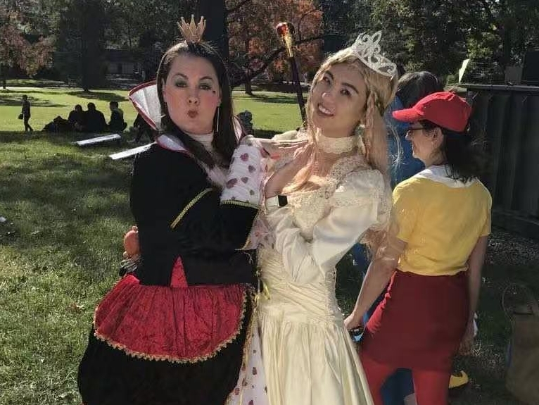 Emily Liu is dressed as Princess Peach for a Halloween costume. She stands next to a person dressed as the Queen of Hearts from Alice and Wonderland.