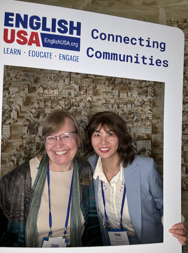 Cheryl Ernst and Emily Liu pose with a photo prop at EnglishUSA.