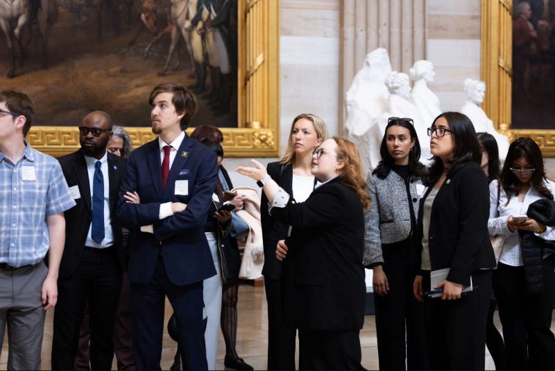 A group of people in business attire inside the Rotunda of the U.S. Capitol Building in Washington, D.C.