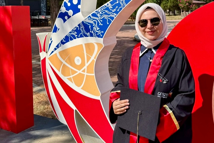Cennet Teker ELI student standing in graduation attire.