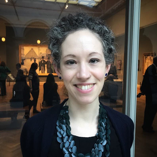 A smiling college student inside an art gallery