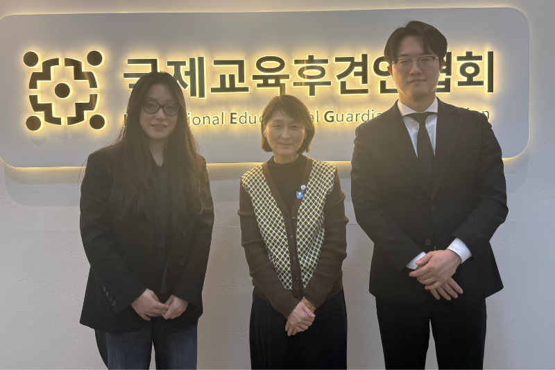 Ana Kim stands with two employees of the International Educational Guardian Association, smiling.