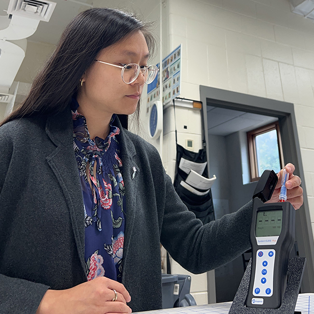 A college intern tests samples inside a laboratory.