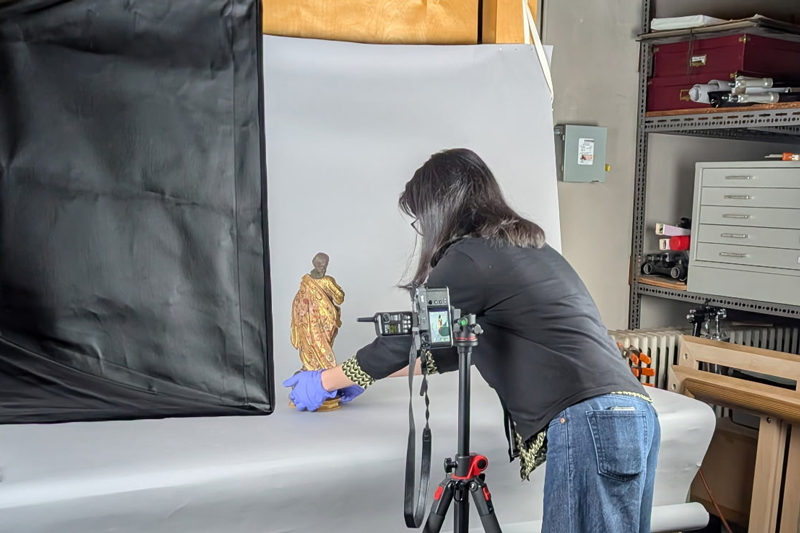 UD Class of 2029 art conservation major Téa Chu Vitale photographing a polychromy statue of a saint.