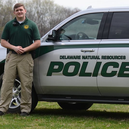 Brandon Pellegrini standing next to DE Natural Resources Police truck Man standing next to DE Natural Resources Police truck