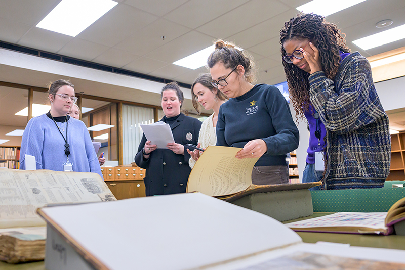 A group of UD museum studies scholars examine a collection at a community library.