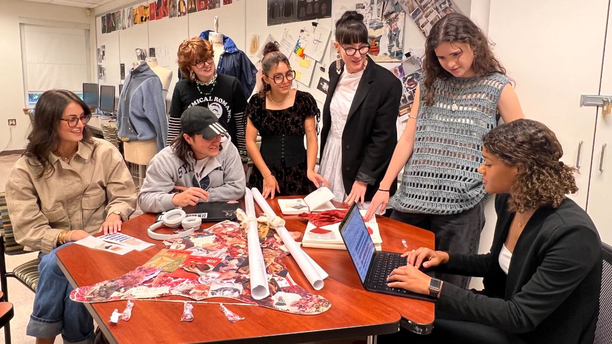 Group of University of Delaware fashion students around a table discussing trends.