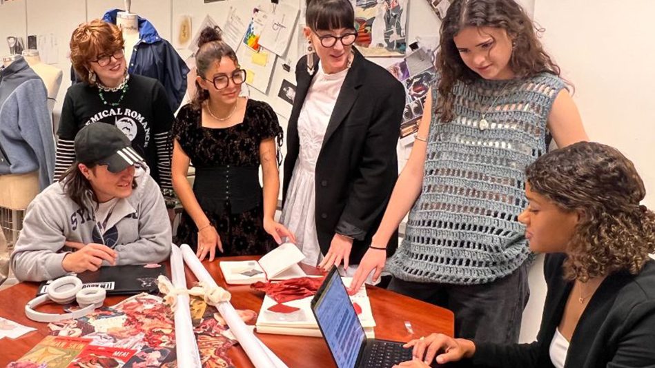 Group of University of Delaware fashion students around a table discussing trends.