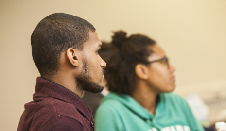 Two students of color listening in a classroom