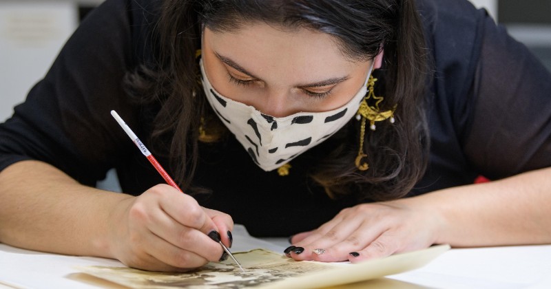 Student doing retouches on work of art Student doing retouches on work of art