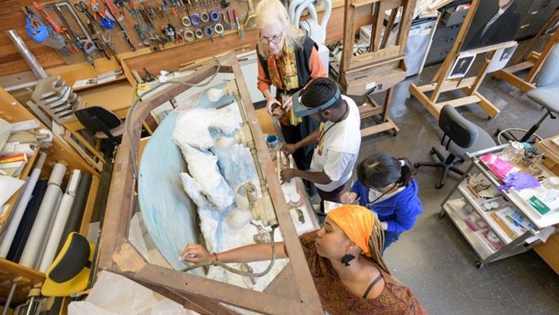 ​TIP-C students cleaning the Matthew Henson diorama