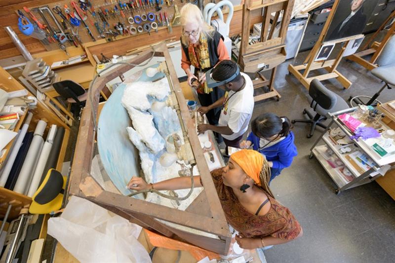 HBCU students cleaning the Matthew Henson diorama
