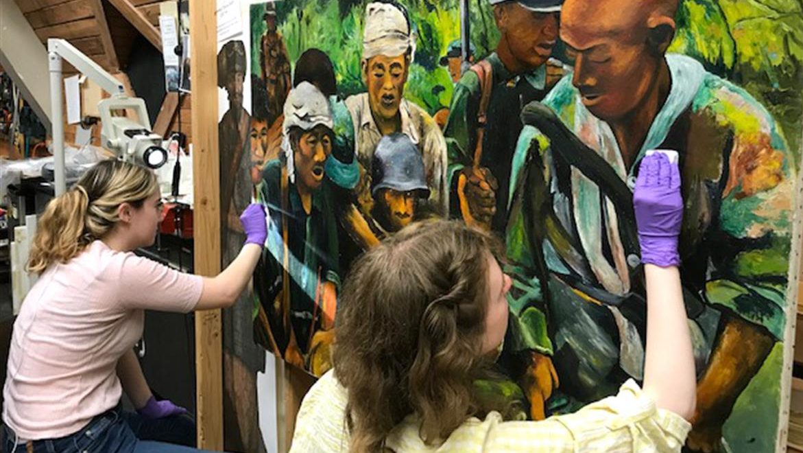 ​Undergraduates Hannah Blank and Miriam-Helene Rudd treating a painting as part of an internship led by Dr. Joyce Hill Stoner at Winterthur Museum, Garden & Library. (Image: Joyce Hill Stoner, Winterthur)