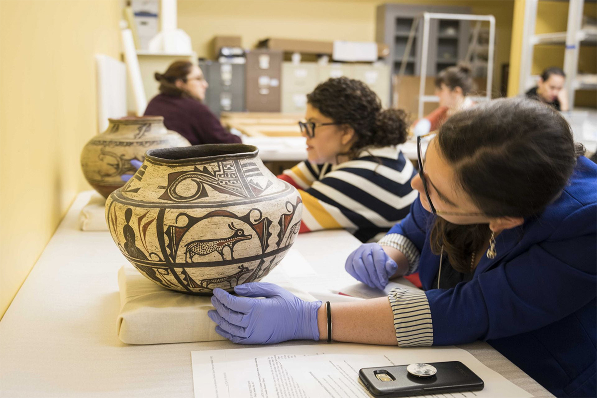 Art History students looking at historic vases