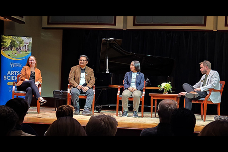 University of Delaware professors sitting on a stage during a panel discussion