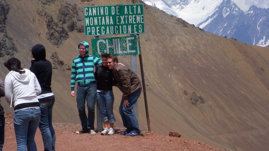 Students outside in Chile near a road sign for study abroad