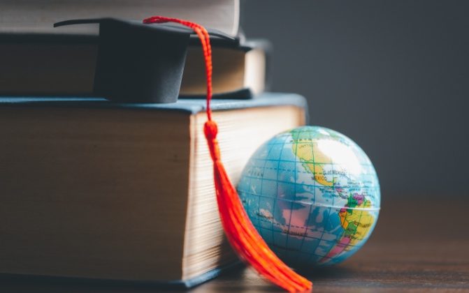 Pile of textbooks with tiny globe Pile of textbooks with tiny globe