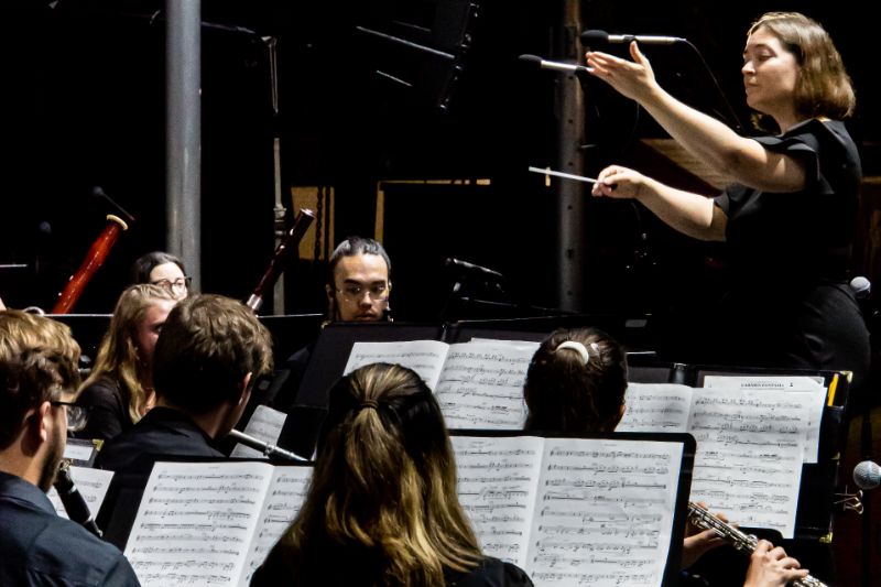 Lauren Reynolds conducting in front of students on stage