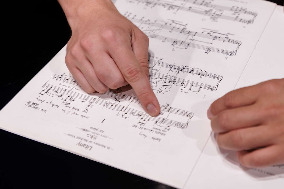 Music composition faculty with student pointing at music on paper