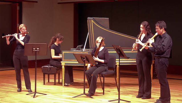 Students playing on stage woodwinds and piano