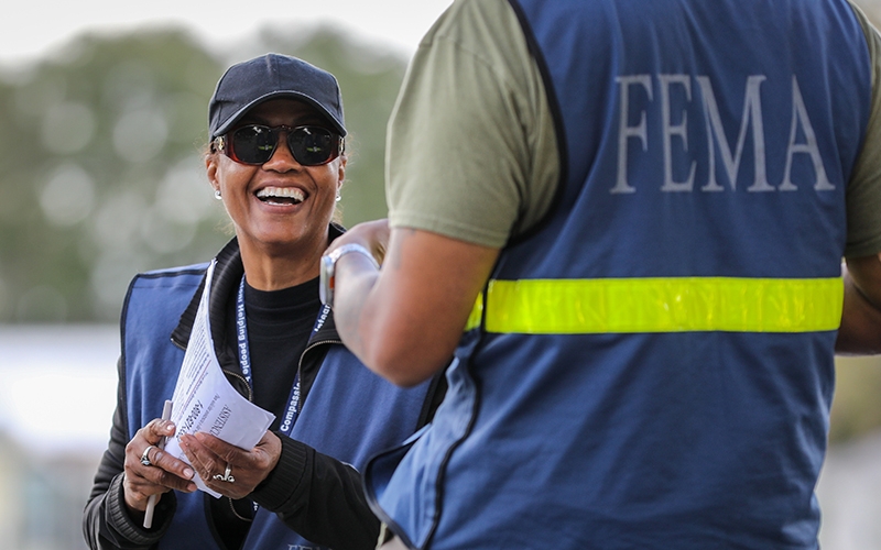Two employees wearing FEMA uniforms working on site.