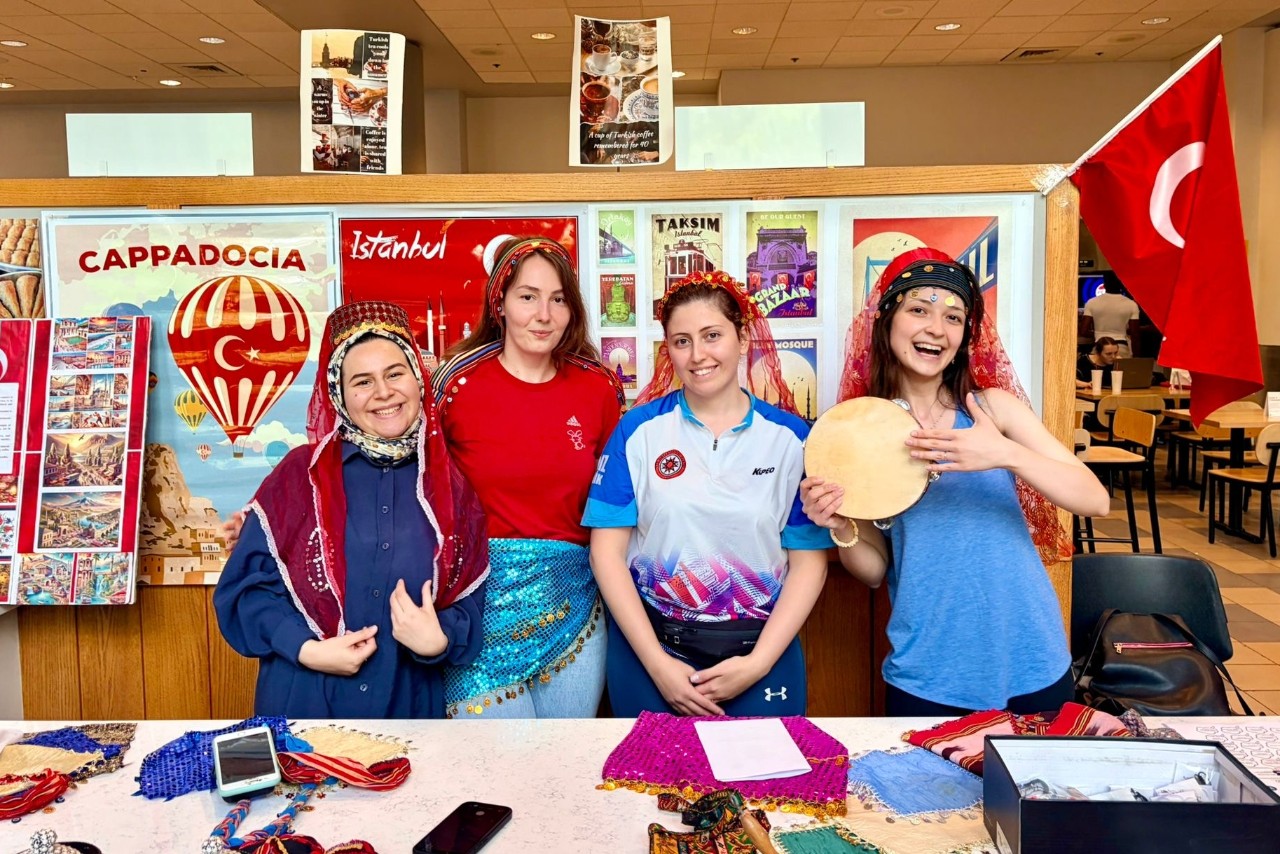 ELI Turkish students stand at a booth to share their culture at the international coffee hour.