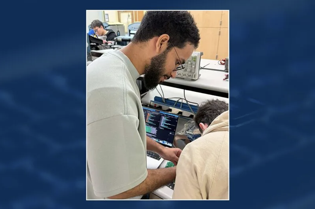 Al Darwashi works on a computer with a collaborator.