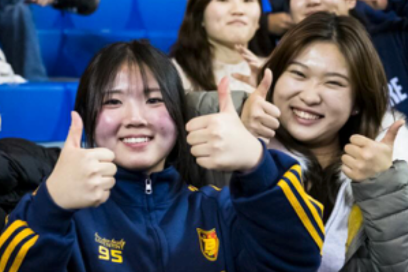 Minjoo Jo (right) attends a UD football game with a friend.
