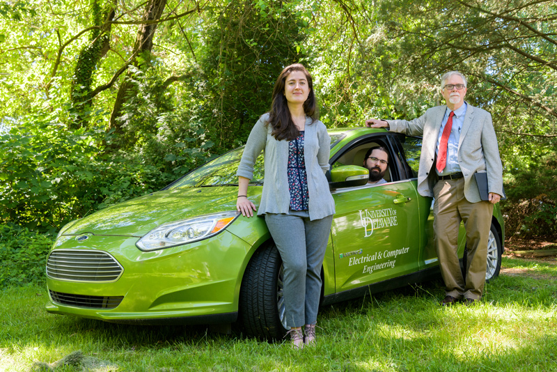 From left to right, the University of Delaware’s Sara Parkison, Rodney McGee and Willett Kempton are shown with a UD test vehicle used in the research for V2G technology that enables electric car batteries to draw energy from and discharge energy back to the electric grid.