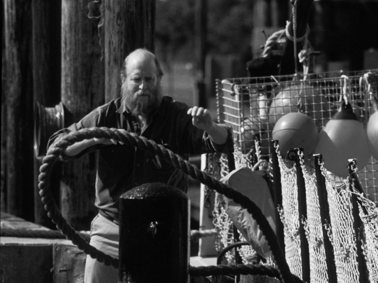 1950s-era photo of fisherman securing boat to dock